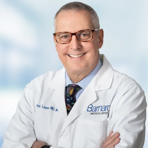 Portrait of Dr. James Loomis smiling in a white Barnard Medical Center coat