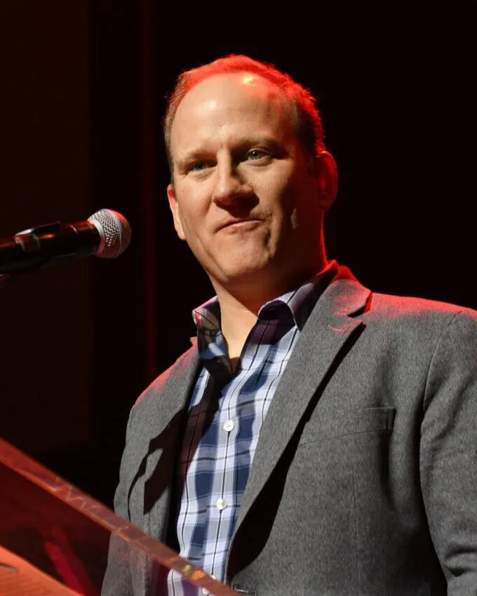 Portrait of Dr. Wes Sechrest in a grey blazer speaking at a podium
