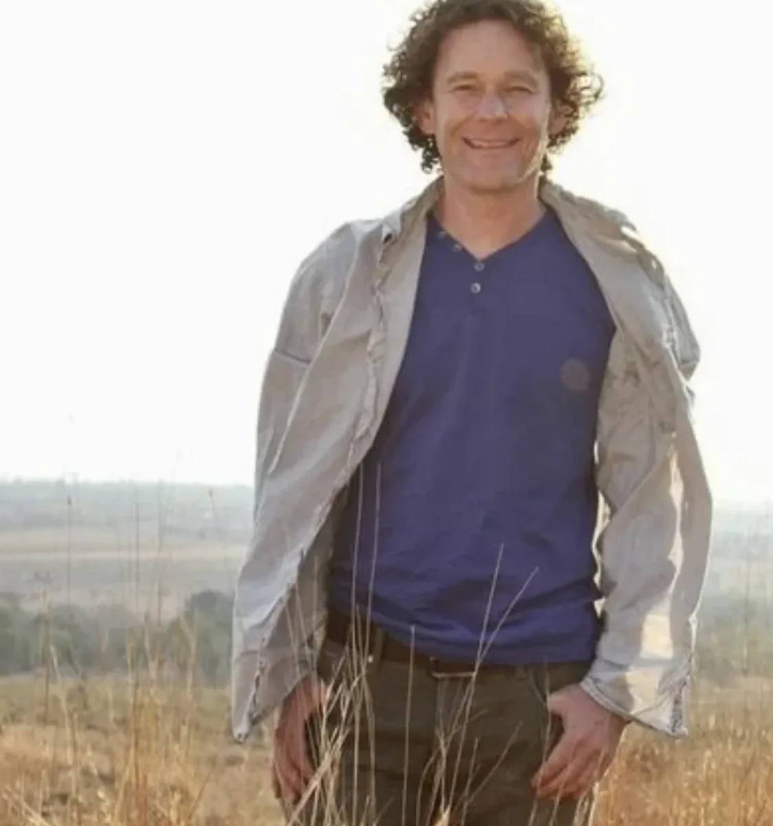 Portrait of Albertus Louw smiling in a dry grassland setting
