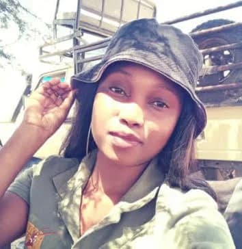 Portrait of Kethabile Modise in a bucket hat and uniform beside a safari vehicle
