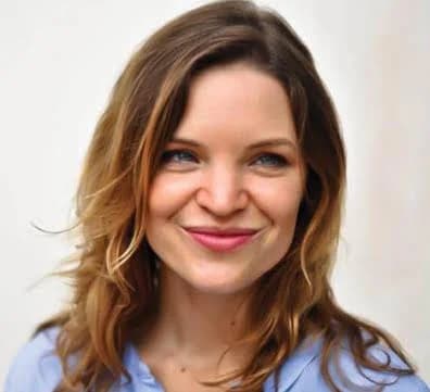Portrait of Klara Schade smiling against a pale wall
