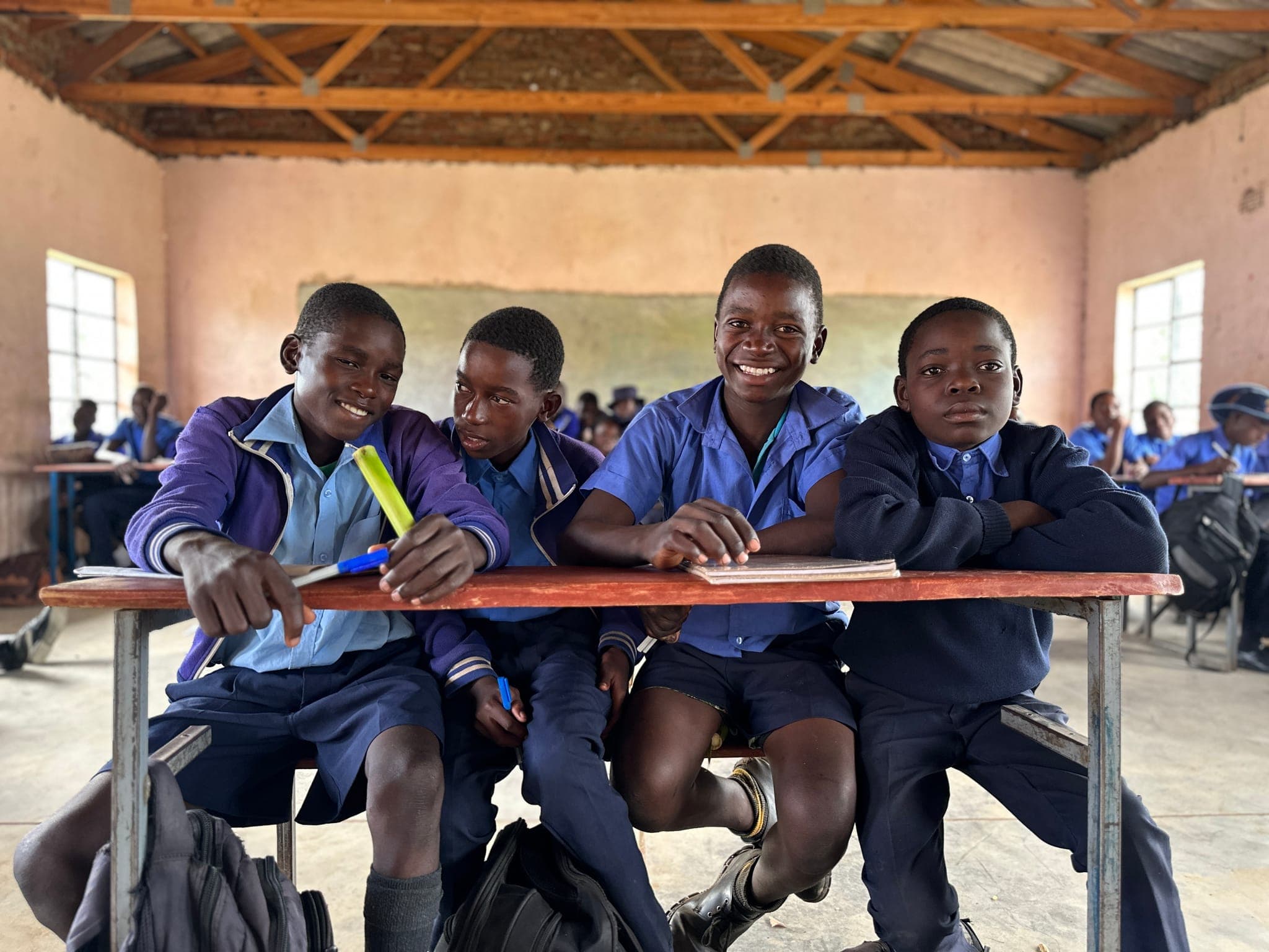 Schoolboys sitting together at a classroom desk in Zimbabwe
