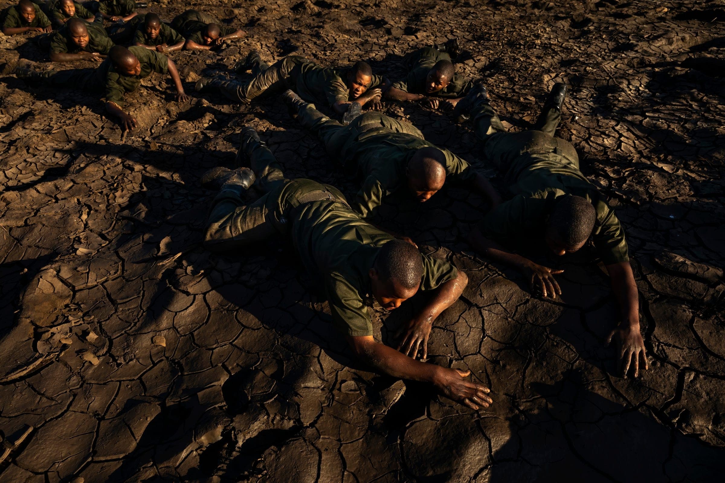 Rangers crawling across cracked mud during training in the Zambezi Valley