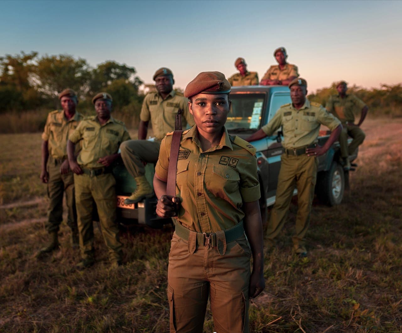 A female ranger standing in front of her ranger unit and patrol vehicle in Zimbabwe